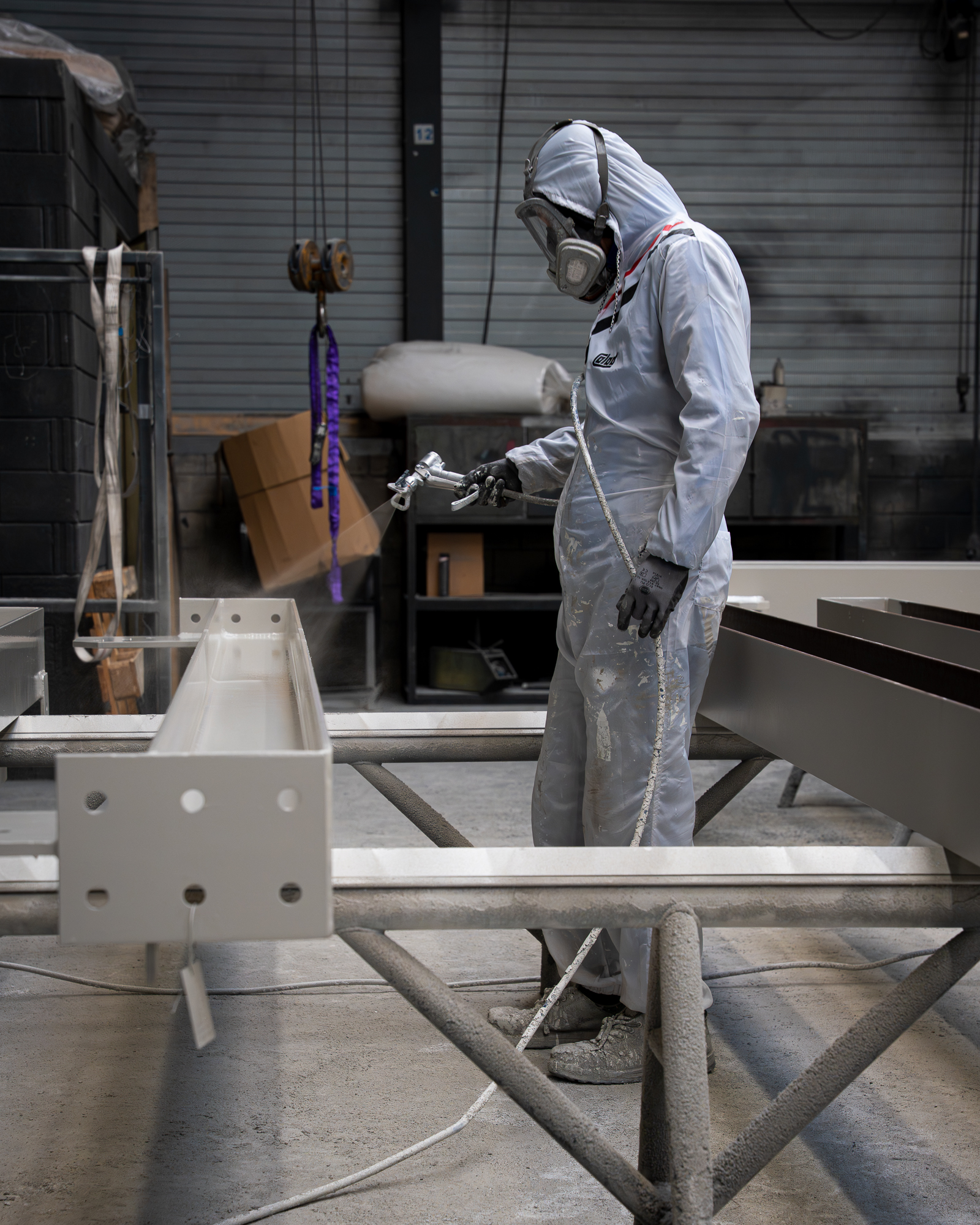 Medewerker is metalen balken brandwerend aan het spuiten